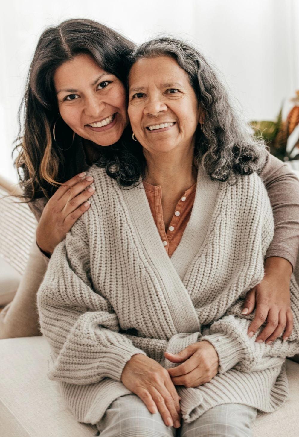 A caregiver embracing an elderly woman warmly, showing emotional support and companionship.