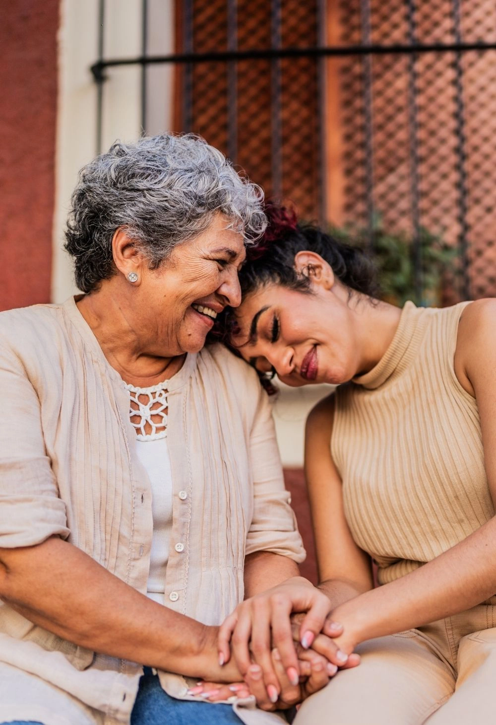 Emotional Support for Senior Care A caregiver sitting with an elderly woman, holding hands and sharing a gentle moment of connection.