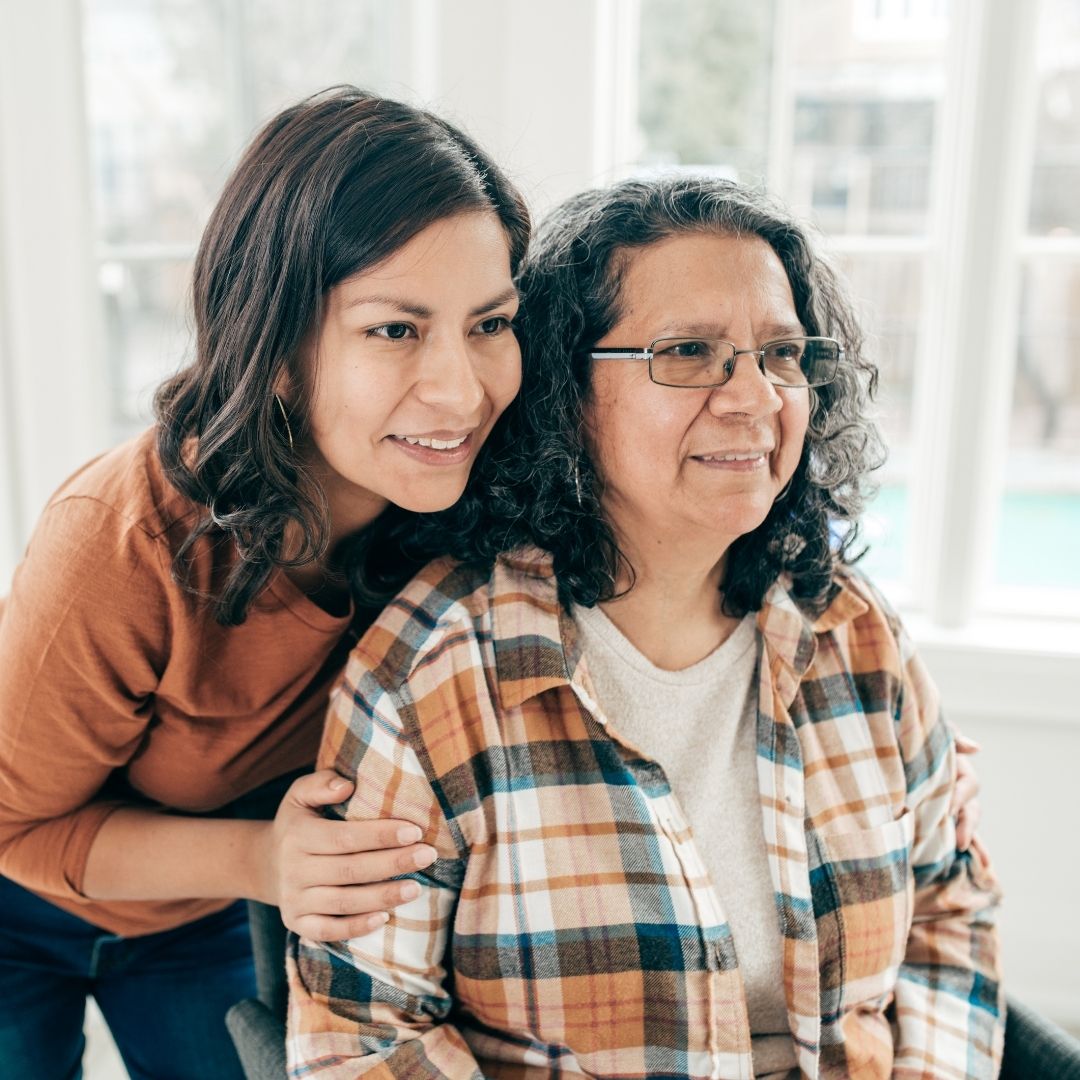 Caregiver supporting an elderly woman while sitting together indoors, showing comfort and trusted home care in Imperial Valley.