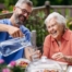 A caregiver applies summer Caregiving Tips including helping a senior stay hydrated.